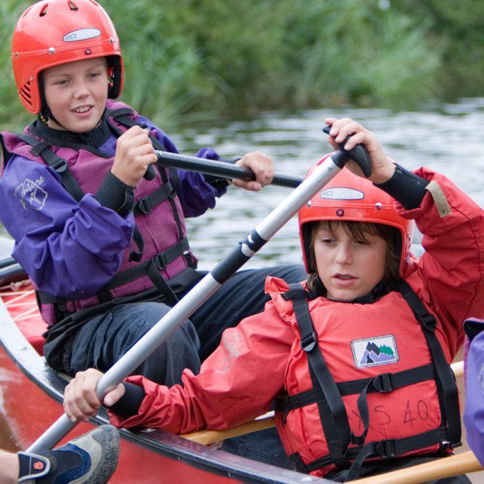 Seconday school children doing the watersports activity open canoeing at Wood N Wheels Adventure Centres